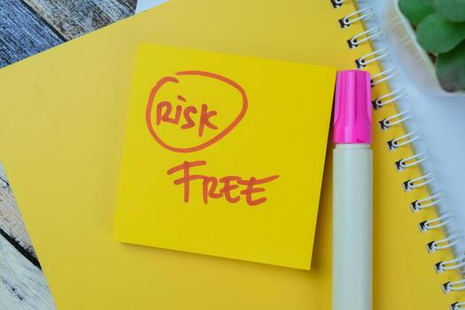 Concept of Risk Free write on sticky notes isolated on Wooden Table. photo
