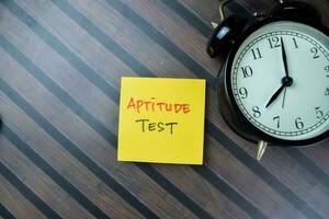 Concept of Aptitude Test write on sticky notes isolated on Wooden Table. photo