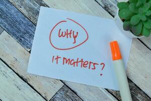 Concept of Why it Matters write on sticky notes isolated on Wooden Table. photo