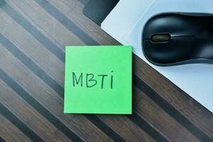 Concept of MBTI write on sticky notes isolated on Wooden Table. photo