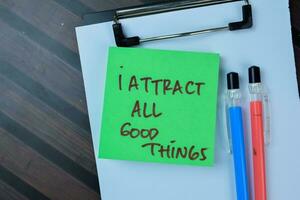 Concept of I Attract All Good Things write on sticky notes isolated on Wooden Table. photo