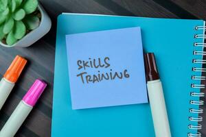 Concept of Skills Training write on sticky notes isolated on Wooden Table. photo