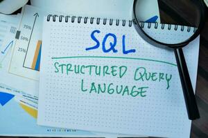 Concept of SQL - Structured Query Language write on book isolated on Wooden Table. photo