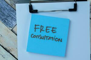 Concept of Free Consultation write on sticky notes isolated on Wooden Table. photo