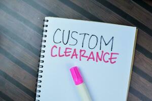 Concept of Custom Clearance write on book isolated on Wooden Table. photo
