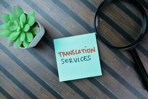 Concept of Translation Services write on sticky notes isolated on Wooden Table. photo