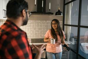 Indian woman talking to latino man in the kitchen. Lifestyle, healthy eating, multi ethnic concept. photo