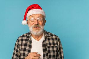 Portrait of Surprised Santa Claus on blue background with copy space - emotions and winter holidays concept photo