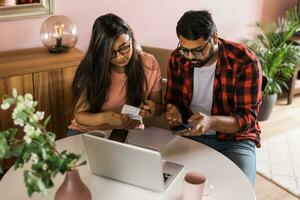 grave esposa y marido planificación presupuesto, comprobación finanzas, enfocado joven mujer utilizando en línea calculadora y contando cuentas o impuestos, hombre utilizando computadora portátil, en línea bancario servicios. foto