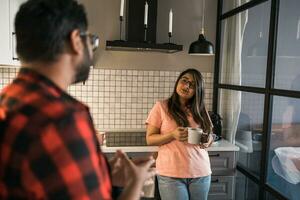 Indian woman talking to latino man in the kitchen. Lifestyle, healthy eating, multi ethnic concept. photo