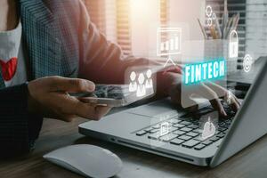 fintech financiero tecnología criptomoneda inversión y digital dinero, negocio persona utilizando ordenador portátil computadora en oficina escritorio con fintech icono en vr pantalla. foto