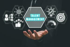 Talent management concept, Businessman hand holding talent management icon on virtual screen. photo