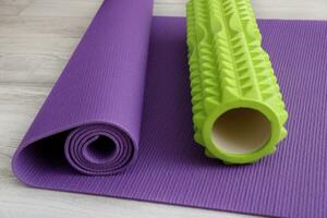 lime massage roller on a lilac gymnastic mat photo