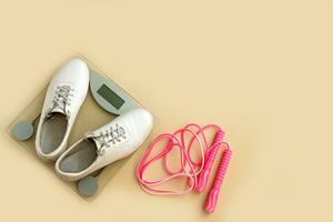 scales, jump rope and sneakers on a light background, weight loss photo