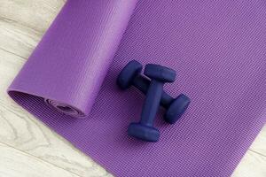 dumbbells on a lilac gymnastic mat, sports at home photo