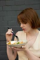 Young woman enjoying the taste of quinoa and salmon salad photo