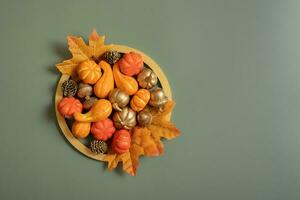 Golden frame with pumkins, roses and maple leaves. Autumn minimalist aesthetic concept photo