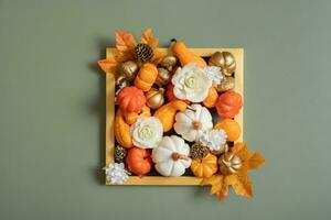 Golden frame with pumkins, roses and maple leaves. Autumn minimalist aesthetic concept photo