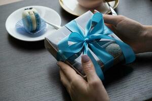 Chocolate craft candy with ribbon in gift box with female hand photo