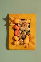 Wooden frame with pumkins, roses and maple leaves. Autumn minimalist aesthetic concept photo