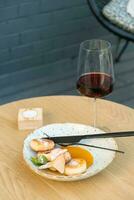 A glass of wine with cheesecakes on plate on a wooden table photo