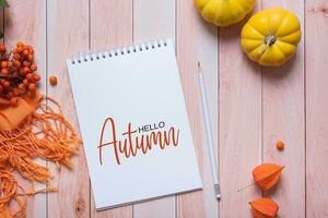 Hello Autumn tetx and autumn cozy decor on wooden background top view, flat lay. photo