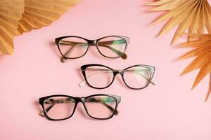 Eyeglasses on pink background. Optical store, vision test, stylish glasses concept photo