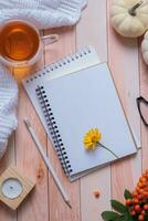 Blank sheet of paper and autumn cozy decor and tea cup top view. Copy space for autumn text photo