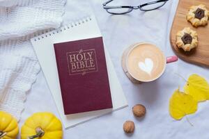 Holy Bible and autumn cozy decor top view. Bible study fall concept photo