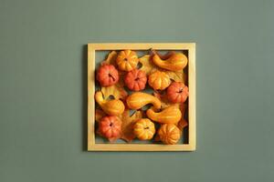 Golden frame with pumkins, roses and maple leaves. Autumn minimalist aesthetic concept photo