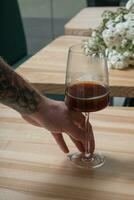 Man hand with filter coffee in wineglass photo