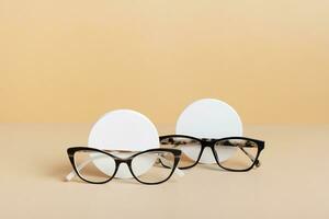 Gypsum elements with eyeglasses on colored background. Optical store, vision test, stylish glasses concept photo