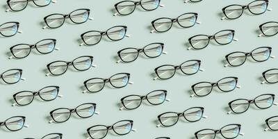 Glasses for vision on a green background. Optical store, vision test, stylish glasses concept. Banner with pattern photo