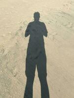 silhouette of a person walking on the beach photo