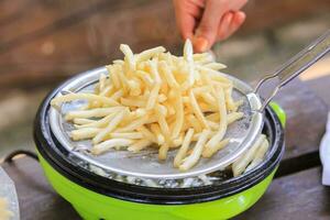 French fries cooking on deep fryer. photo