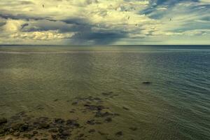 Aerial drone seascape of crystal clear lagoon sea water surface with rocks and cloudy sky photo