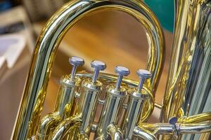 un parte de el clásico viento instrumento con latón detalles. cerca arriba de trompeta dedo botones válvulas foto