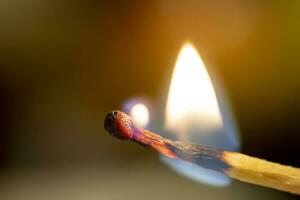 The fire spreads over a wooden stick of match. Close up photo