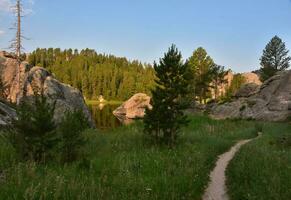 Narrow Trail with Large Rocks Around a Lake photo