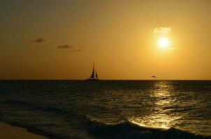 Gorgeous Sun Setting with a Silhoetted Sailboat photo