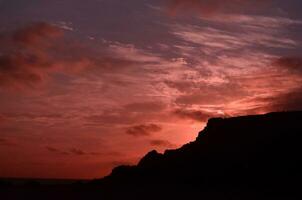 rosado cielo terminado volcánico rocas en aruba foto