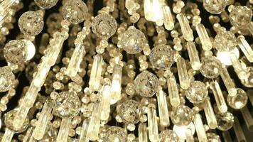 Crystal chandelier close up. Beautiful yellow light reflects through polished Czech glass crystals hanging on a vintage chandelier. video