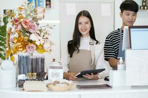 Happy Coffee Shop owner in an apron standing near a bar counter. photo