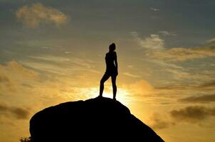 Woman Standing Silhouetted at Sunrise in the Summer photo