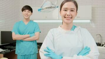 Portrait of two professional dental occupation workers partner in uniform, female dentist and male assistant, teeth healthcare, hygiene work in dental clinic hospital, happy smile, and look at camera. video