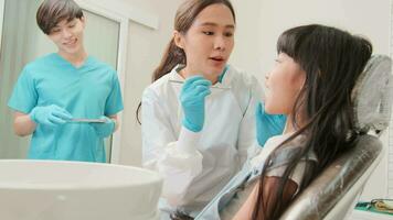 asiatique femelle pédiatrique dentiste et assistant vérifier et examen une peu les filles carie les dents dans dentaire clinique, bien-être hygiène, et professionnel orthodontique soins de santé travail dans enfant hôpital. video