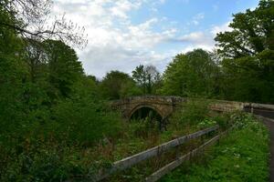 Rural Stone Arched Bridge Over a Small Stream in England photo