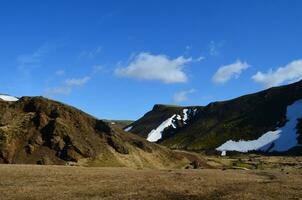 Snow on Mountains Surrounding a Valley in Remote Iceland photo