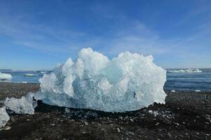 Unique shape of a Icelandic iceberg in the beach photo