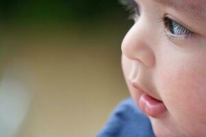 Close Up Shot of Cute Asian Pakistani 4 Months Old Baby Boy, Who is Enjoying at Home Garden at Luton City of England UK. Image Was Captured on July 23rd, 2023 photo